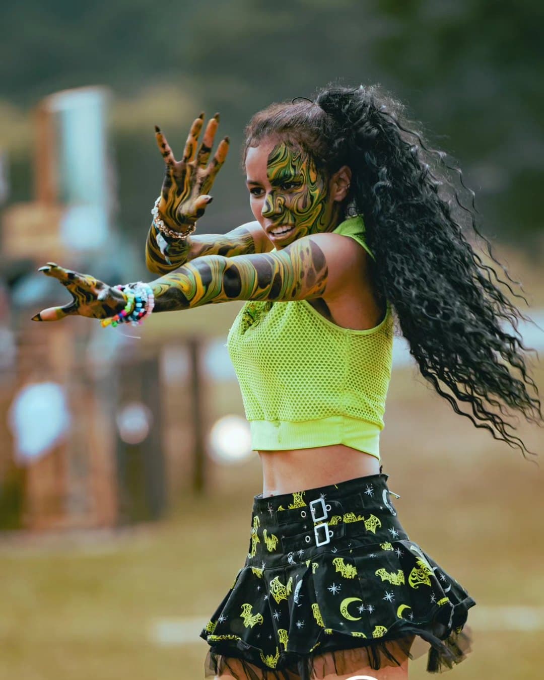 A dancer in neon green performing at Imagine Music Festival