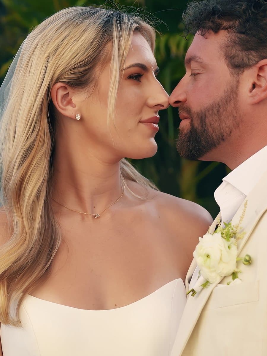 A bride and groom nose to nose among palm leaves at their Virgin Islands wedding